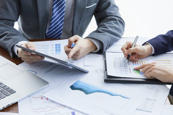 Businessmen in elegant suits at a business meeting discussing a new project in the office Business factoring Canada solutions for cash flow